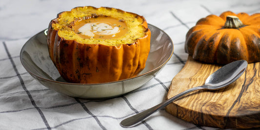 Vegan pumpkin soup served in whole roasted pumpkin